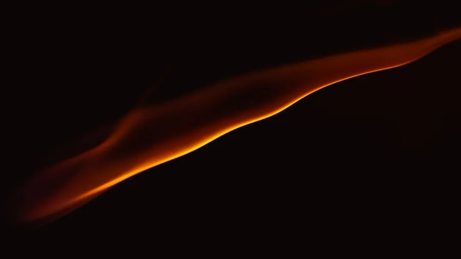 Onda de luz naranja sobre fondo negro, como una curva de tendencia